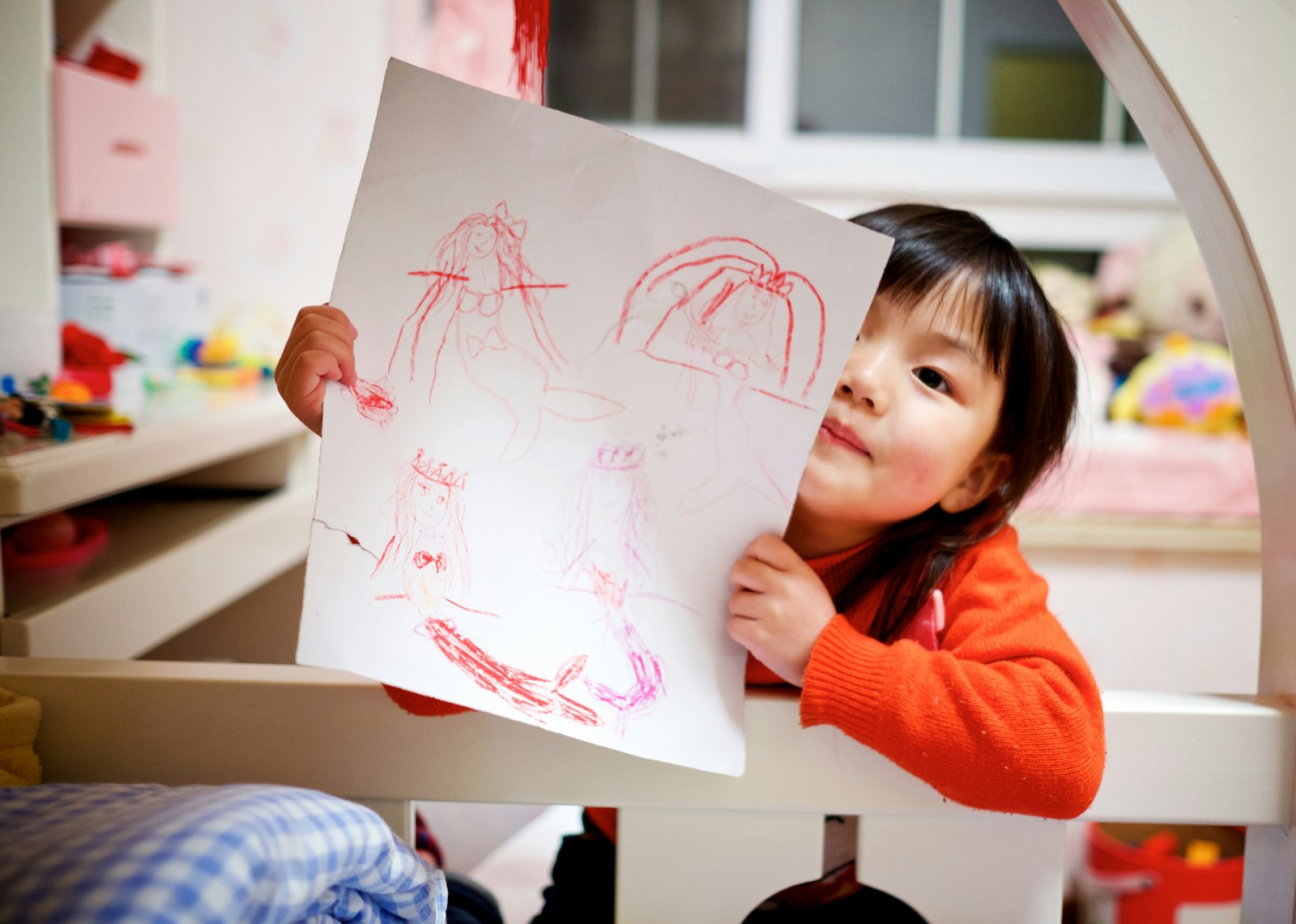 Una bambina mostra orgogliosa il suo disegno