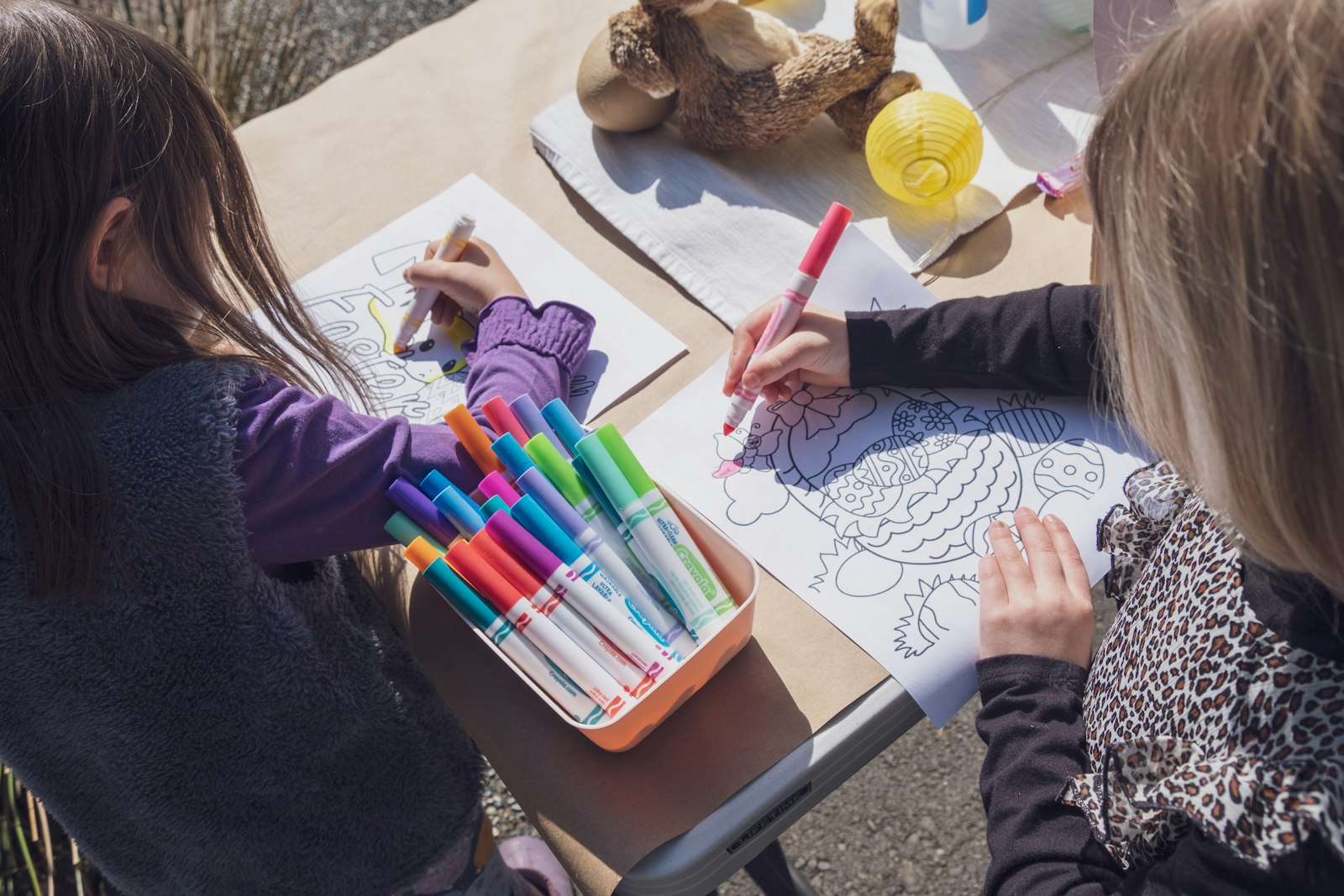 Bambine disegnano insieme con i pennarelli durante un laboratorio