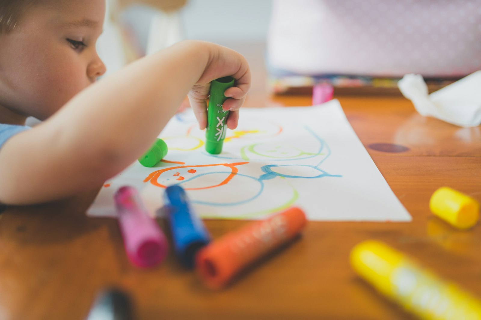 Bambino disegna con i pastelli colorati