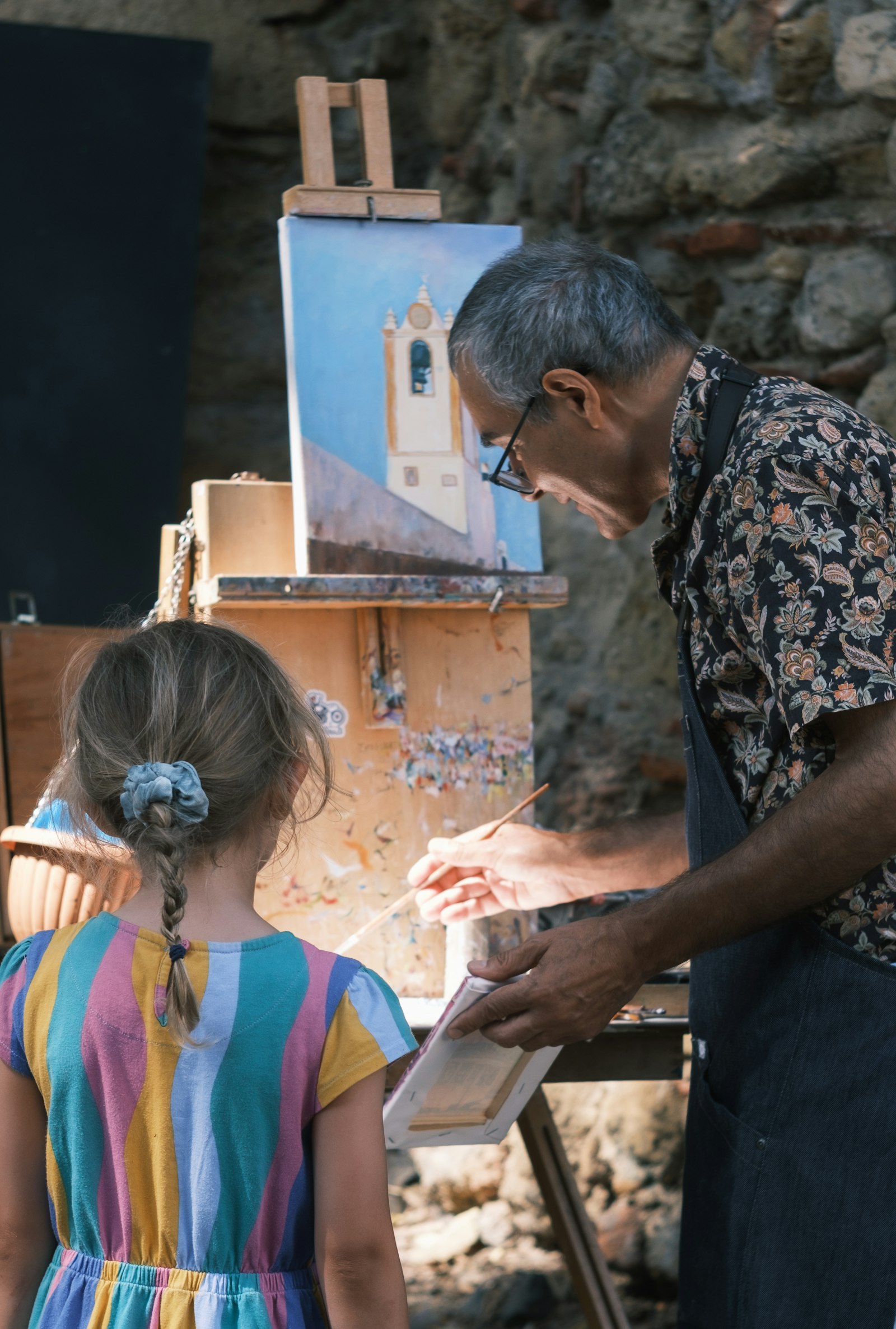 Un'educatrice dipinge insieme a una bambina